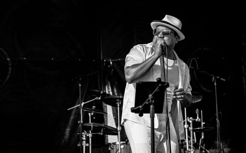 Órale Band vocalist with microphone during an evening performance