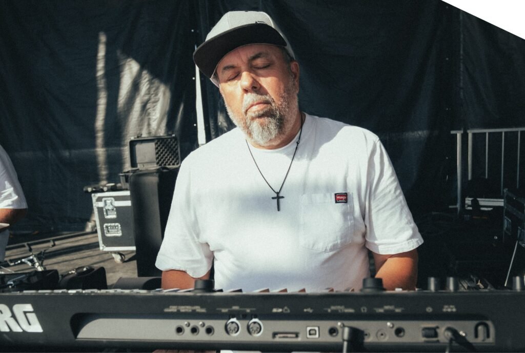 Órale Band keyboard player at the keys during an outdoor festival set